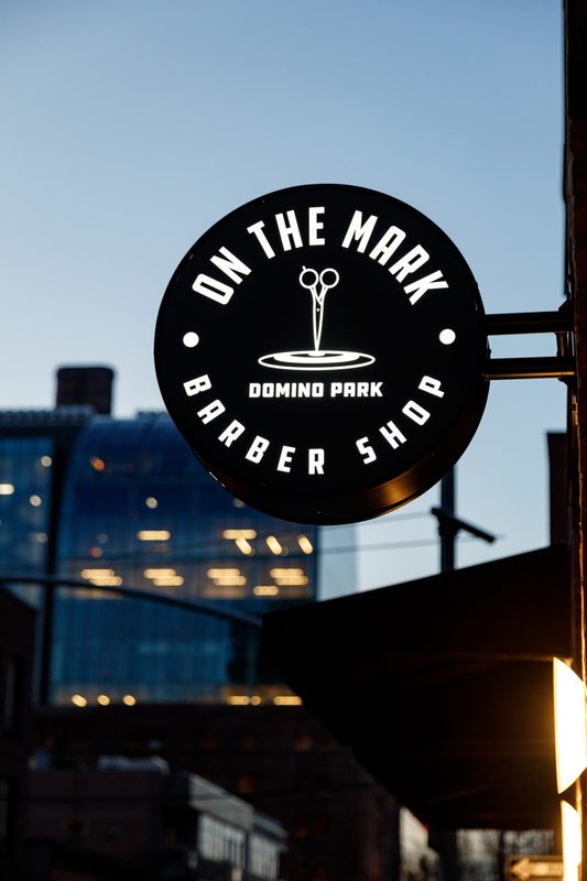 The round On the Mark sign against the dusk sky